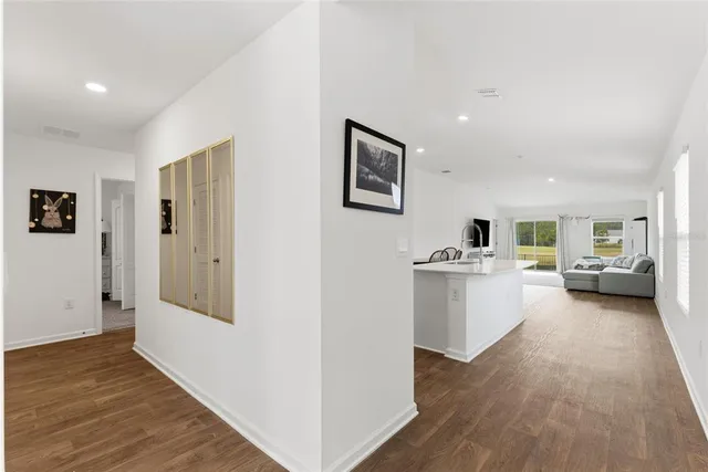 a view of a hallway with bathroom and wooden floor