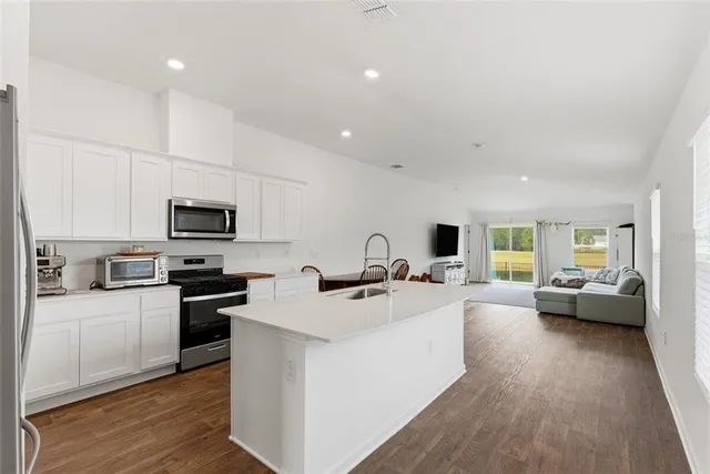a kitchen with sink a counter top space appliances and cabinets