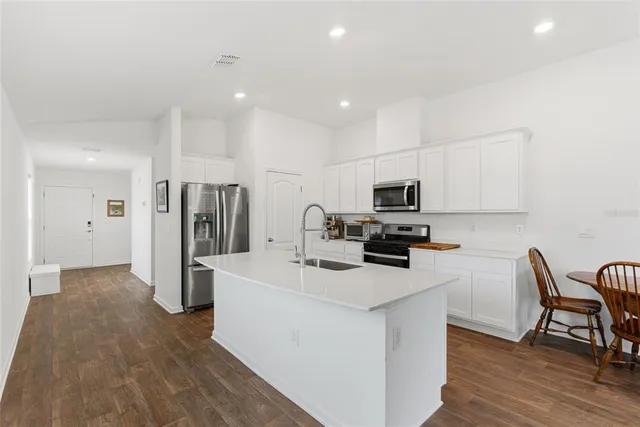 a kitchen with stainless steel appliances a refrigerator and a stove top oven