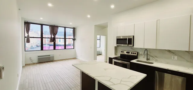 a kitchen with stainless steel appliances kitchen island granite countertop a stove a sink and a microwave