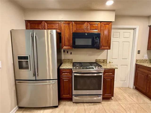 a kitchen with stainless steel appliances a refrigerator stove and microwave