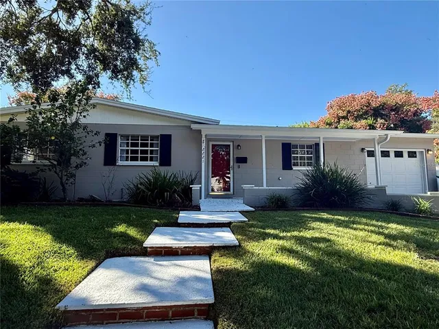 a view of a house with backyard and sitting area