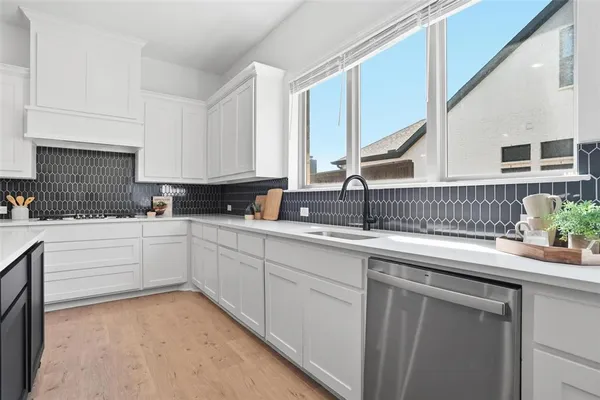 a kitchen with granite countertop a sink and white cabinets