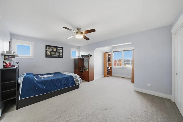 a spacious bedroom with a bed and a chandelier
