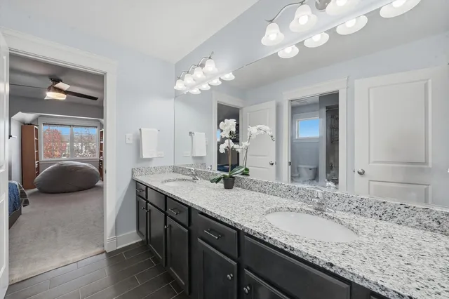 a en suite bathroom with a granite countertop sink and a mirror