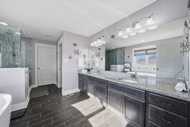 a spacious bathroom with double vanity and a mirror