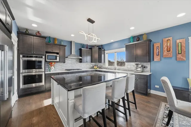 a kitchen with a center island appliances and cabinets