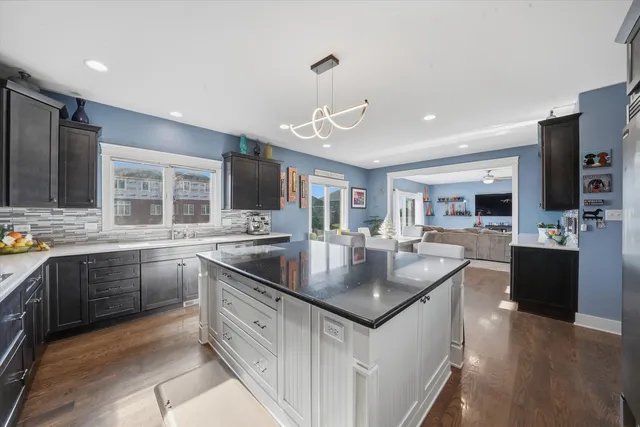 a kitchen with stainless steel appliances granite countertop a sink a stove and a refrigerator