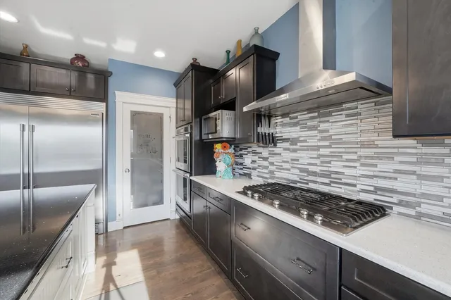 a kitchen with stainless steel appliances granite countertop a stove a refrigerator and a sink