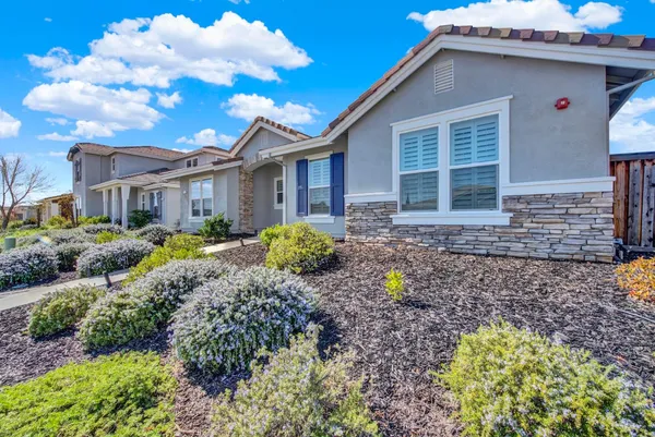 a large kitchen with kitchen island a stove a sink dishwasher a refrigerator and white cabinets with wooden floor