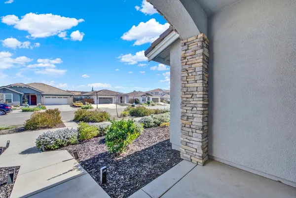 a large white kitchen with a sink a refrigerator and chandelier
