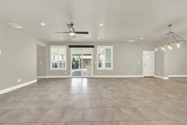 an empty room with chandelier fan