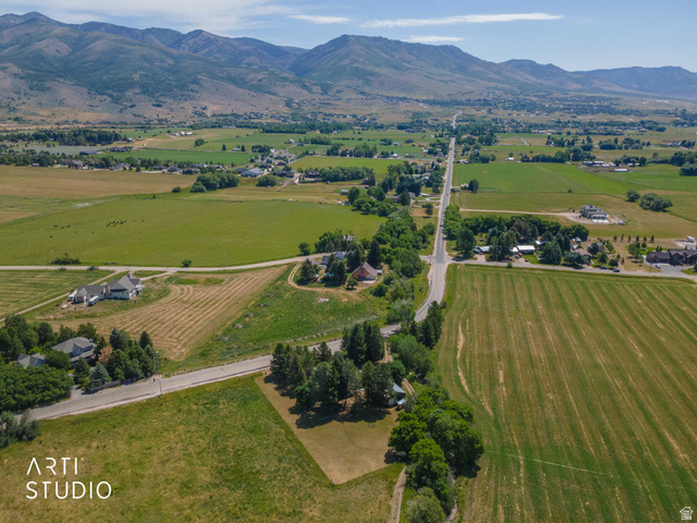 2807 North Ogden Canyon Road Eden, UT 84310 - Photo 62 of 72 Expansive rural landscape featuring a paved road, scattered residential properties, mature trees, open fields, and distant mountains