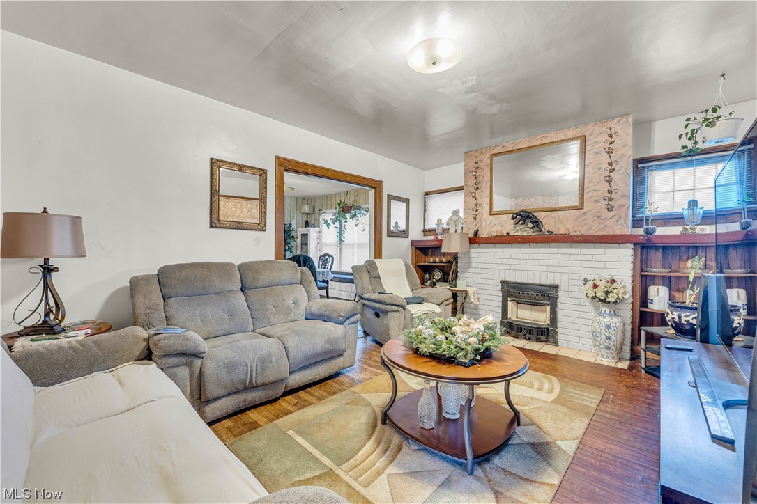 3550 Bosworth Road Cleveland, OH 44111 - Photo 4 of 43 Living room featuring a brick fireplace and hardwood / wood-style floors
