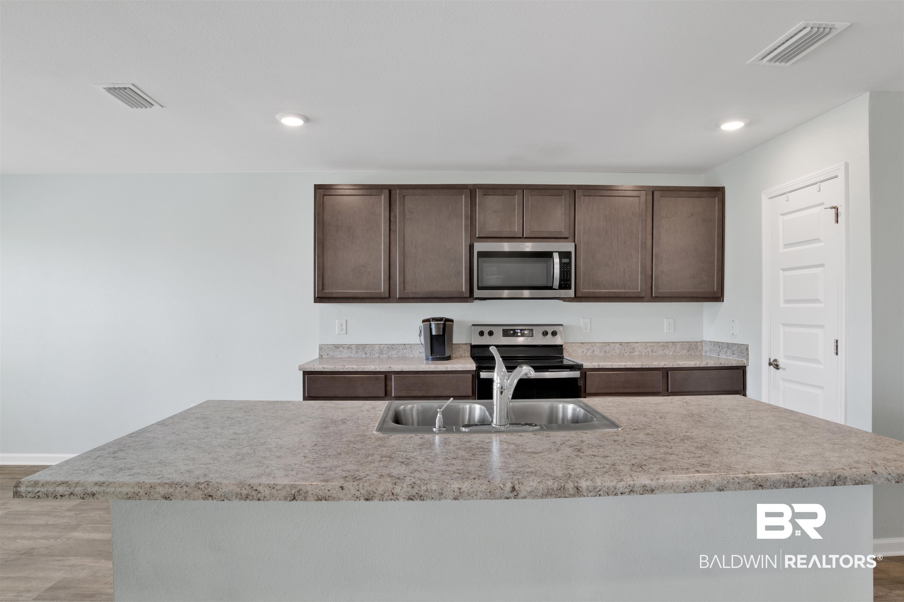 304 Hartenstein Road Foley, AL 36535 - Photo 14 of 28 Kitchen featuring a kitchen island with sink, sink, dark brown cabinets, and stainless steel appliances