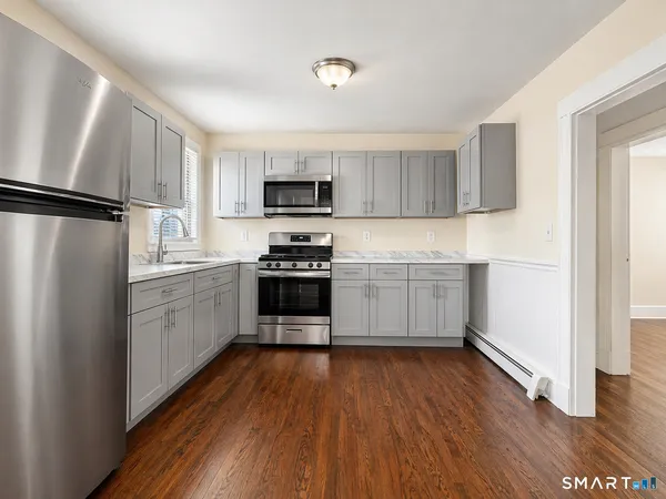 a kitchen with white cabinets and stainless steel appliances