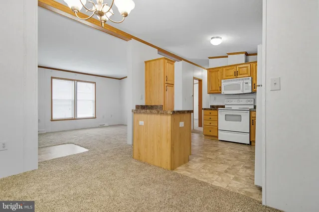an empty room with windows and refrigerator