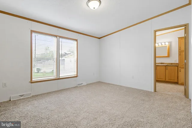 an empty room with a window and a kitchen