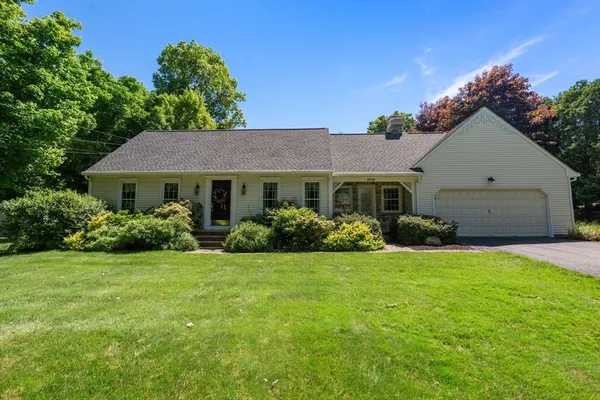 a front view of a house with a garden and yard