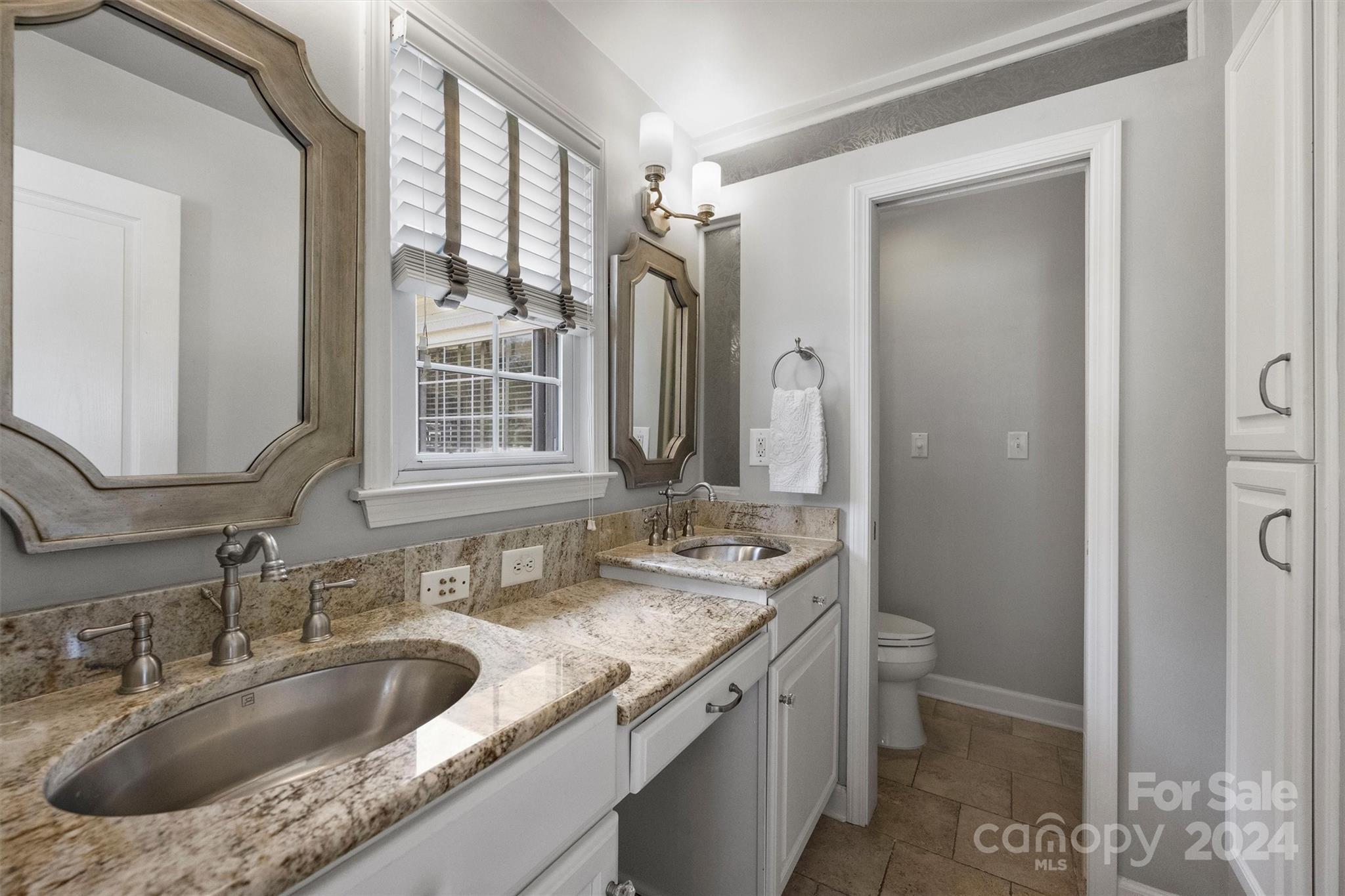 4115 Sulkirk Road Charlotte, NC 28210 - Photo 24 of 39 a bathroom with a granite countertop sink a toilet and a mirror