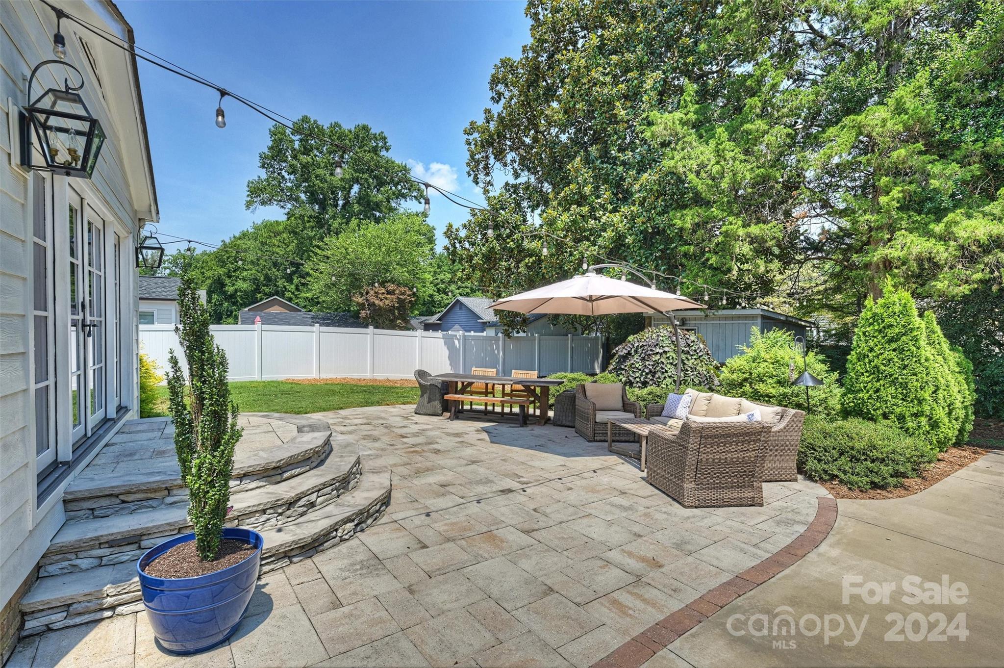 4115 Sulkirk Road Charlotte, NC 28210 - Photo 37 of 39 a backyard of a house with table and chairs under an umbrella