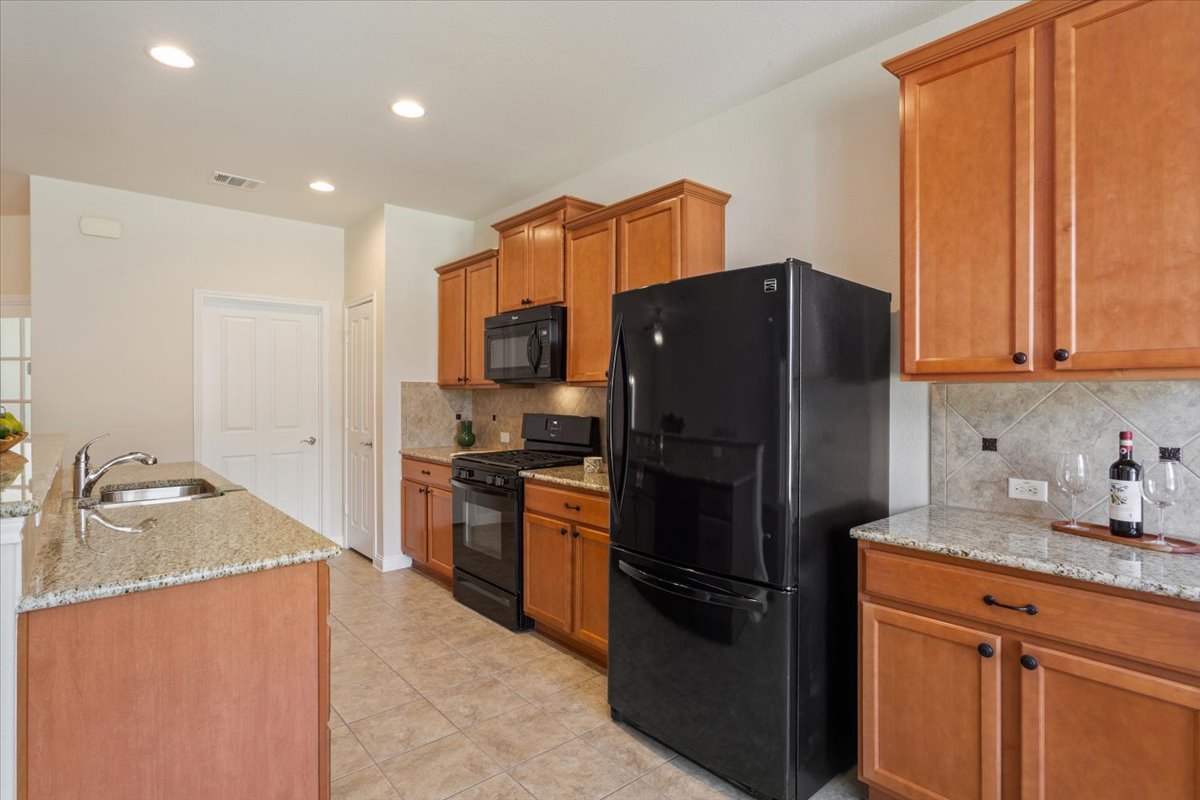 108 Cathedral Mountain Pass Georgetown, TX 78633 - Photo 14 of 36 a kitchen with granite countertop stainless steel appliances and refrigerator