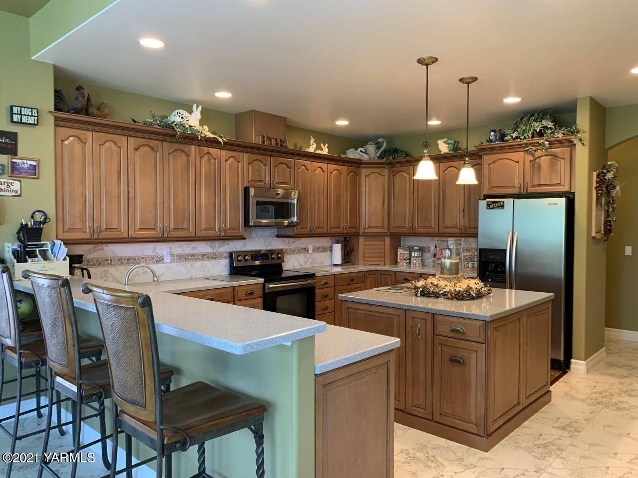 14841 Fisk Road Yakima, WA 98908 - Photo 40 of 59 a kitchen with a sink a refrigerator and chairs