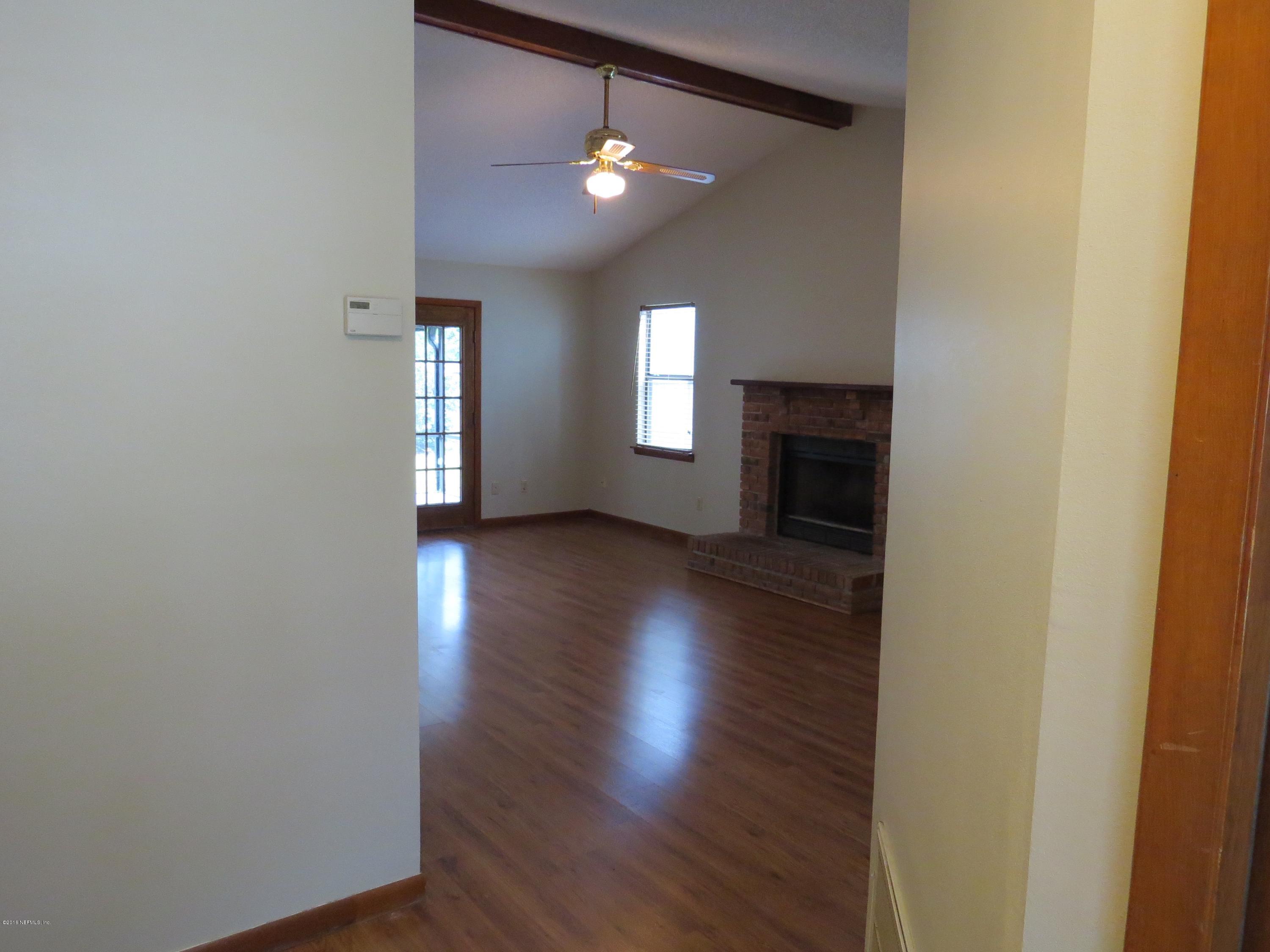 12770 Beaubien Road Jacksonville, FL 32258 - Photo 7 of 46 an empty room with wooden floor and fireplace
