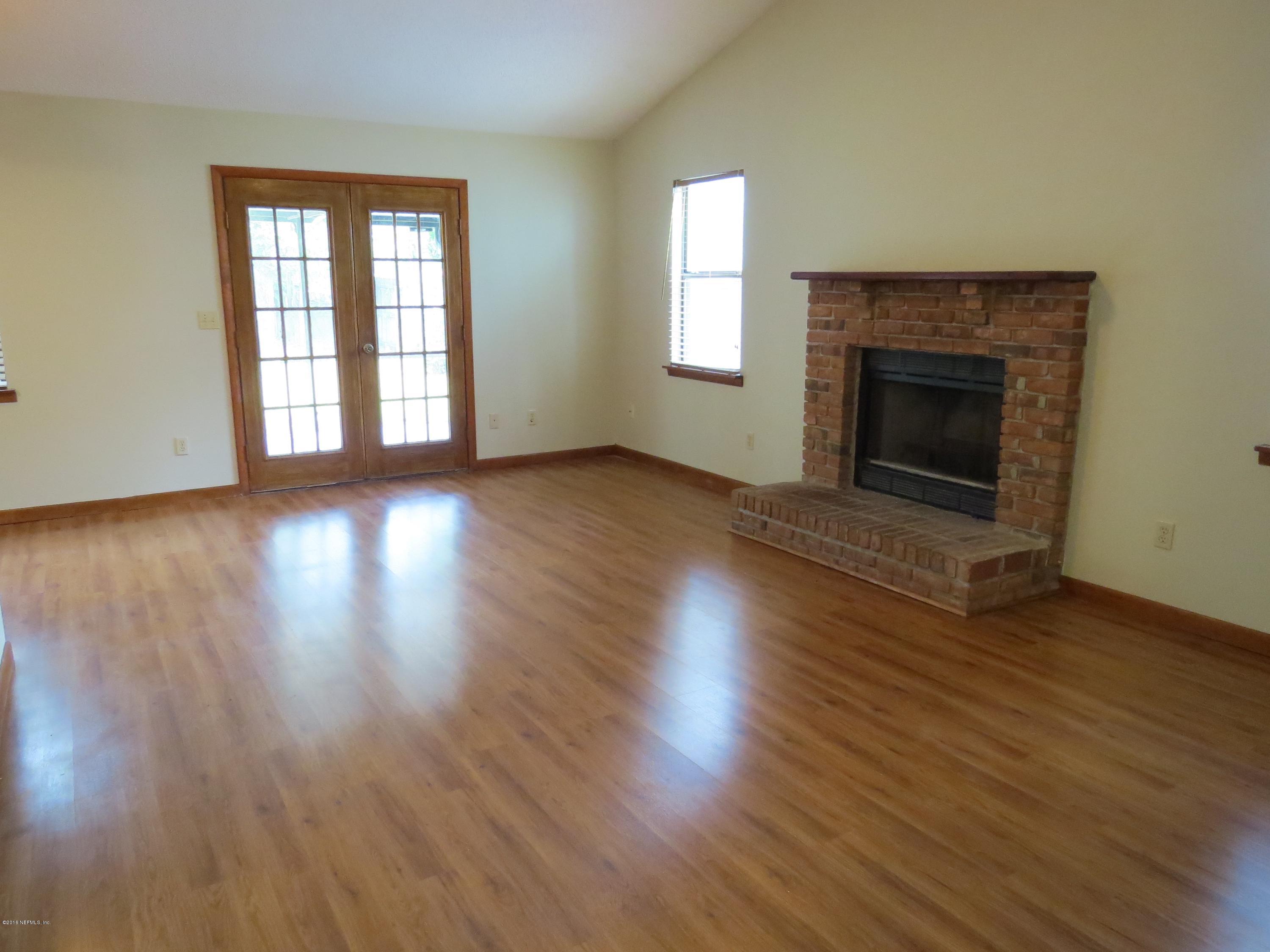12770 Beaubien Road Jacksonville, FL 32258 - Photo 8 of 46 an empty room with wooden floor fireplace and windows