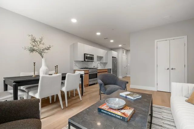 a living room with furniture kitchen view and a table
