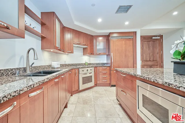 a large kitchen with granite countertop a sink and cabinets