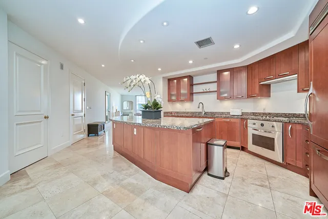 a kitchen with stainless steel appliances granite countertop a stove top oven a sink and a refrigerator