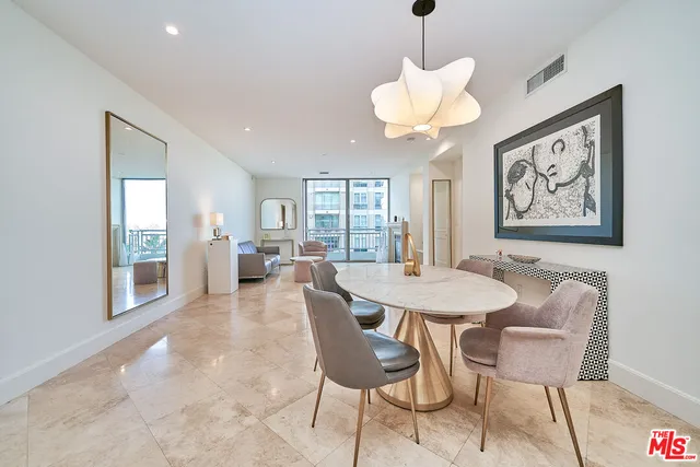 a dining room with wooden floor and a chandelier