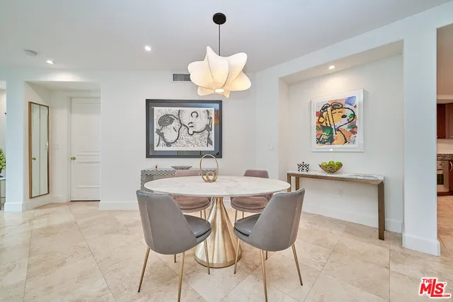 a dining room with wooden floor a chandelier a wooden table and chairs