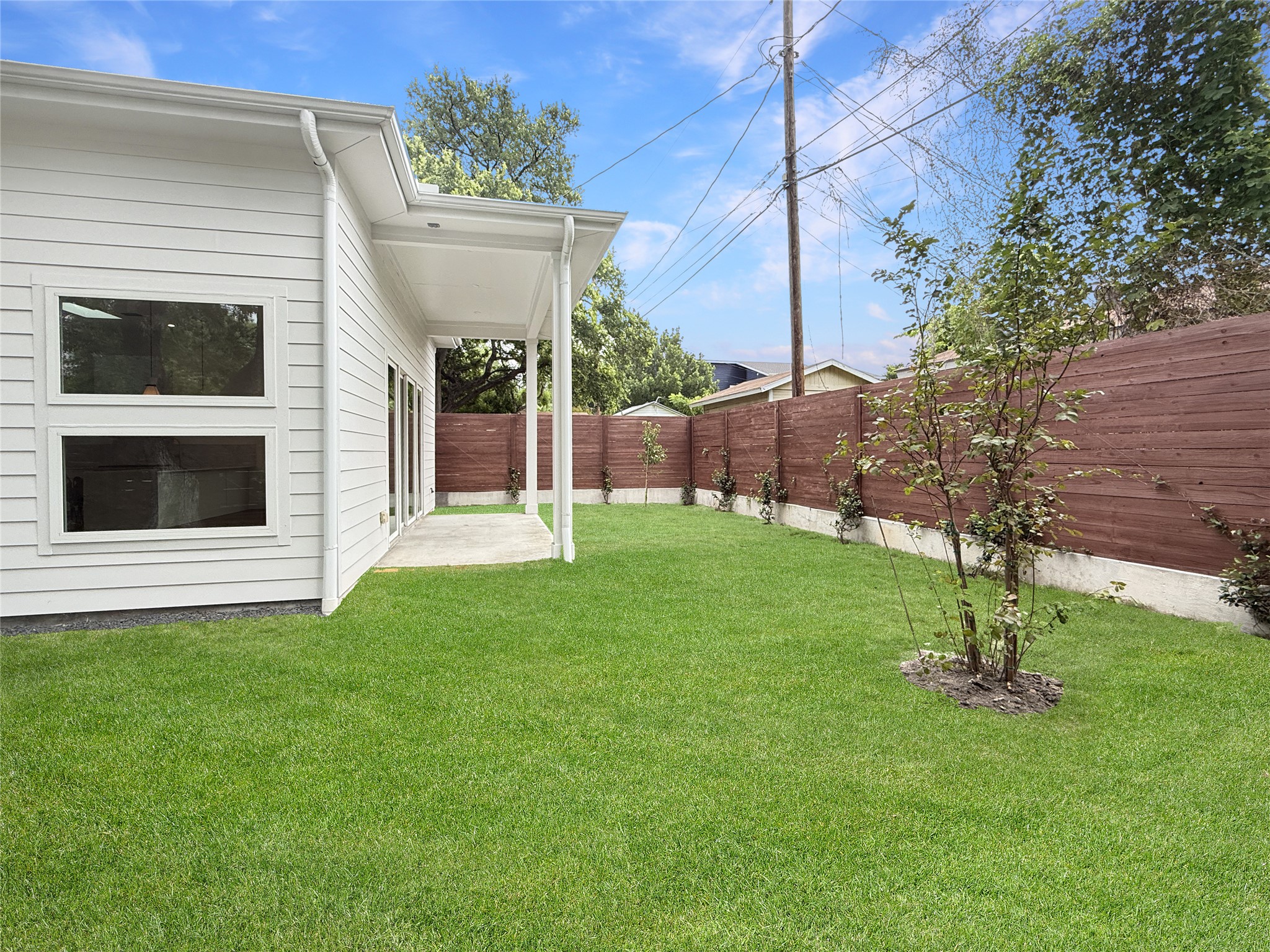 127 Frederick Street Austin, TX 78704 - Photo 33 of 34 Spacious backyard featuring a manicured lawn, a covered patio, and a privacy fence