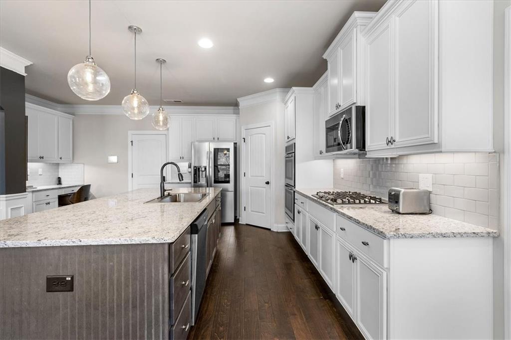 191 Crystal Lake Boulevard Hampton, GA 30228 - Photo 20 of 68 a large kitchen with stainless steel appliances kitchen island granite countertop a sink a stove and a wooden floors