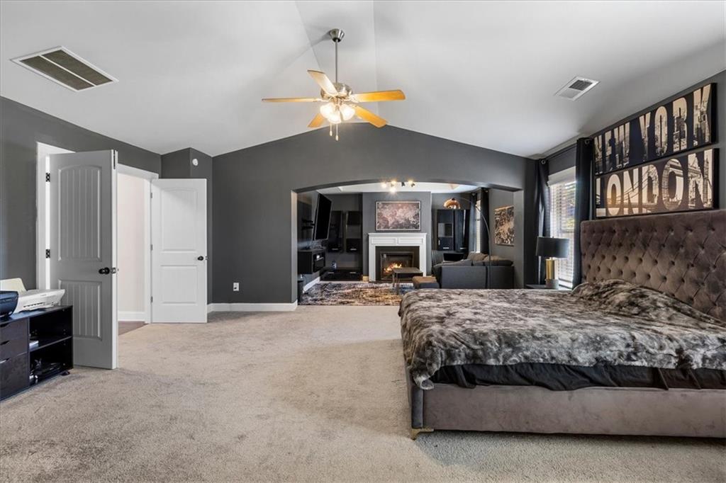 191 Crystal Lake Boulevard Hampton, GA 30228 - Photo 29 of 68 a bedroom with a large bed a chandelier and dresser