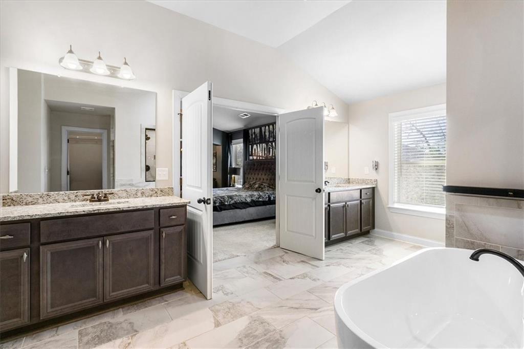 191 Crystal Lake Boulevard Hampton, GA 30228 - Photo 34 of 68 a large white bathroom with a double vanity sink a mirror and a bathtub