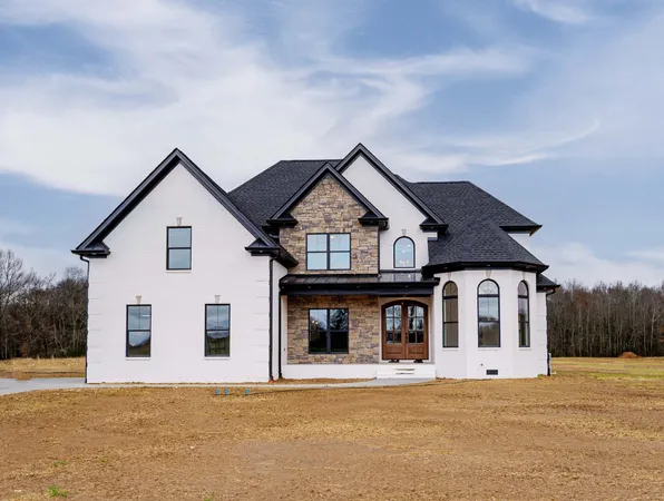 a view of a big house with a big yard and large trees