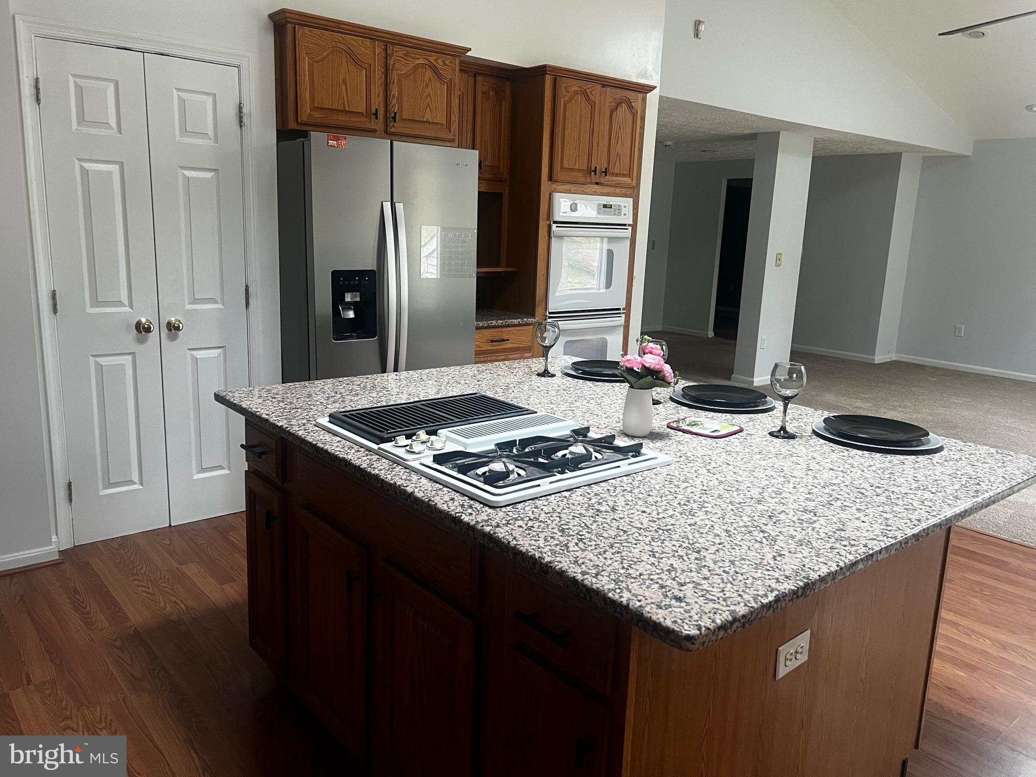 11009 Maiden Drive Bowie, MD 20720 - Photo 2 of 5 a kitchen island with granite countertop a sink stove and refrigerator