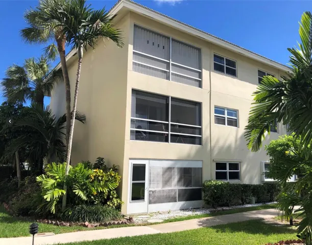 a front view of a house with a yard and potted plants