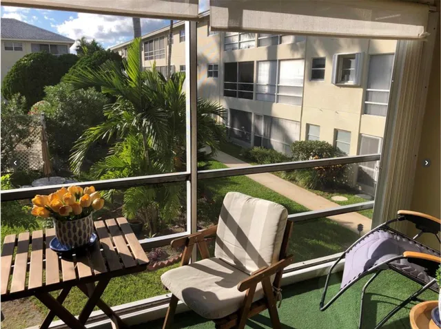 a view of a balcony with chairs and wooden floor