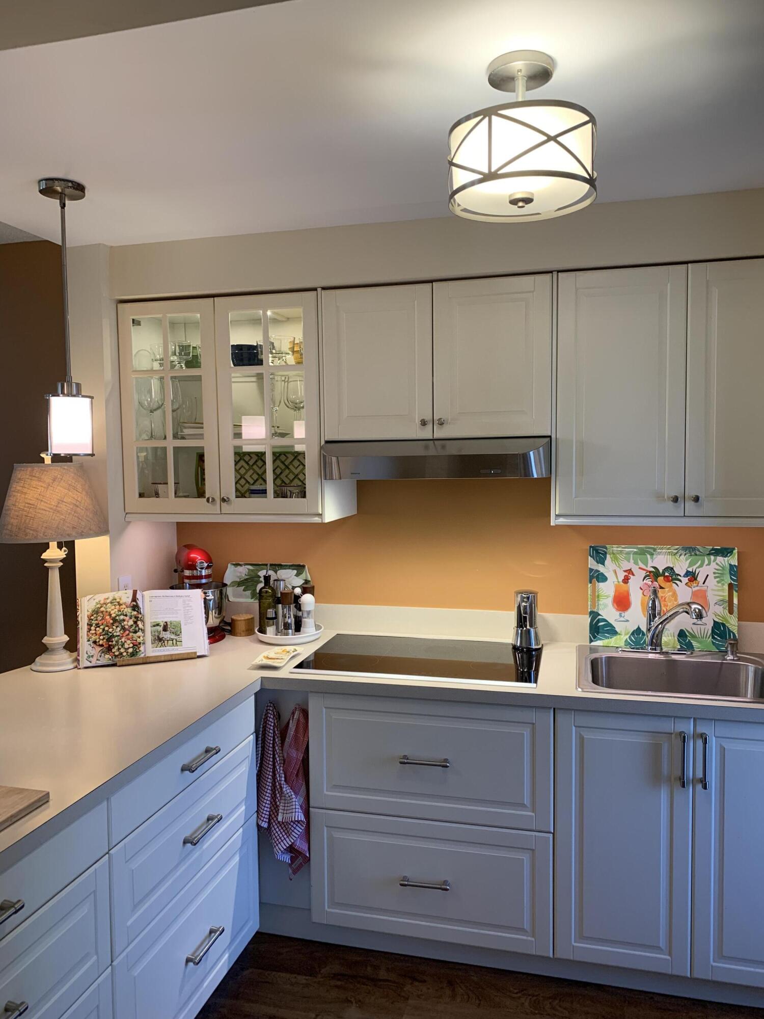 1951 Northeast 39th Street Northeast, Unit 249 Lighthouse Point, FL 33064 - Photo 6 of 23 a kitchen with stainless steel appliances a sink dishwasher and cabinets with wooden floor