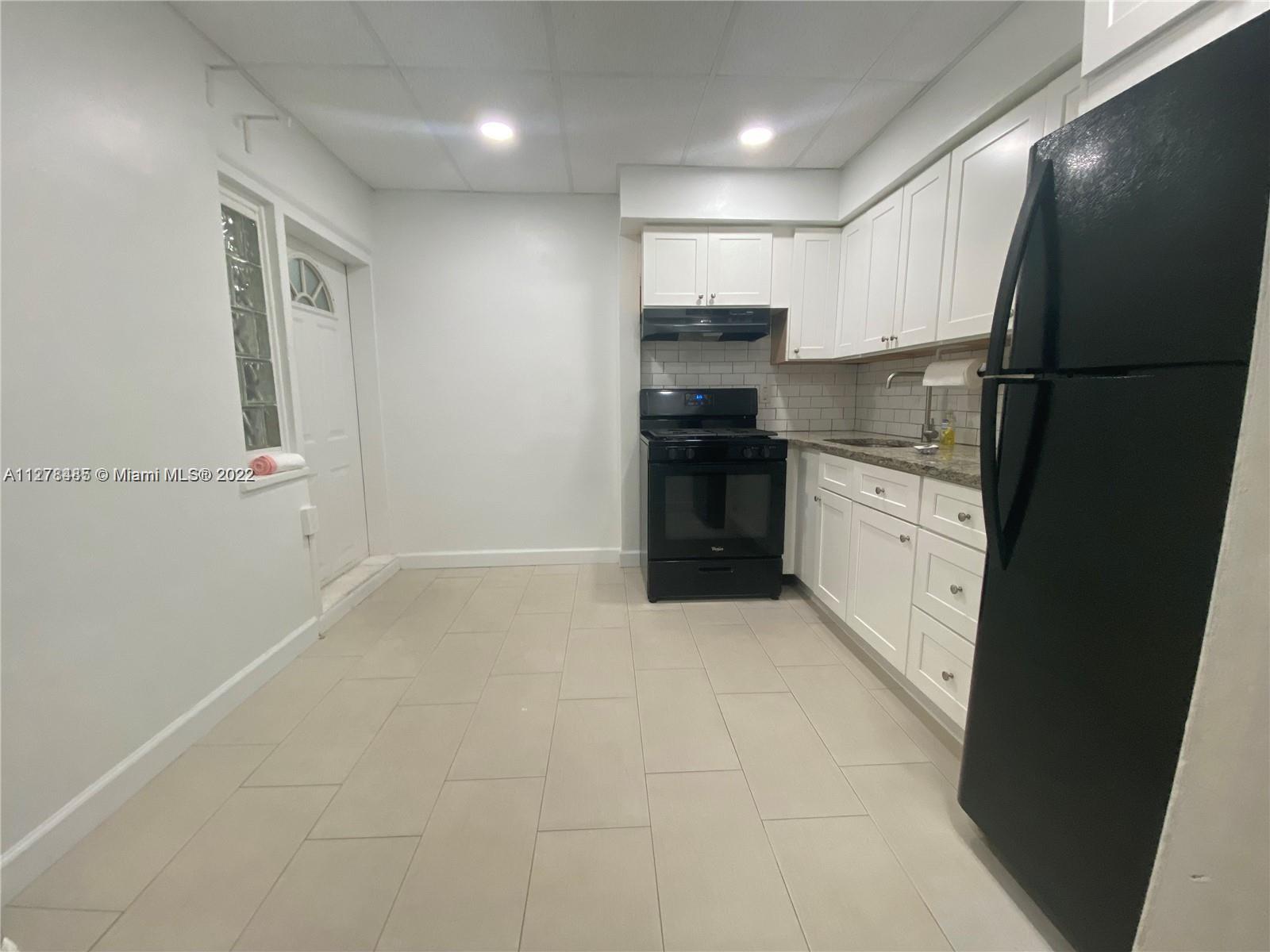 8927 Harding Avenue Surfside, FL 33154 - Photo 14 of 22 a kitchen with stainless steel appliances granite countertop a refrigerator and a sink