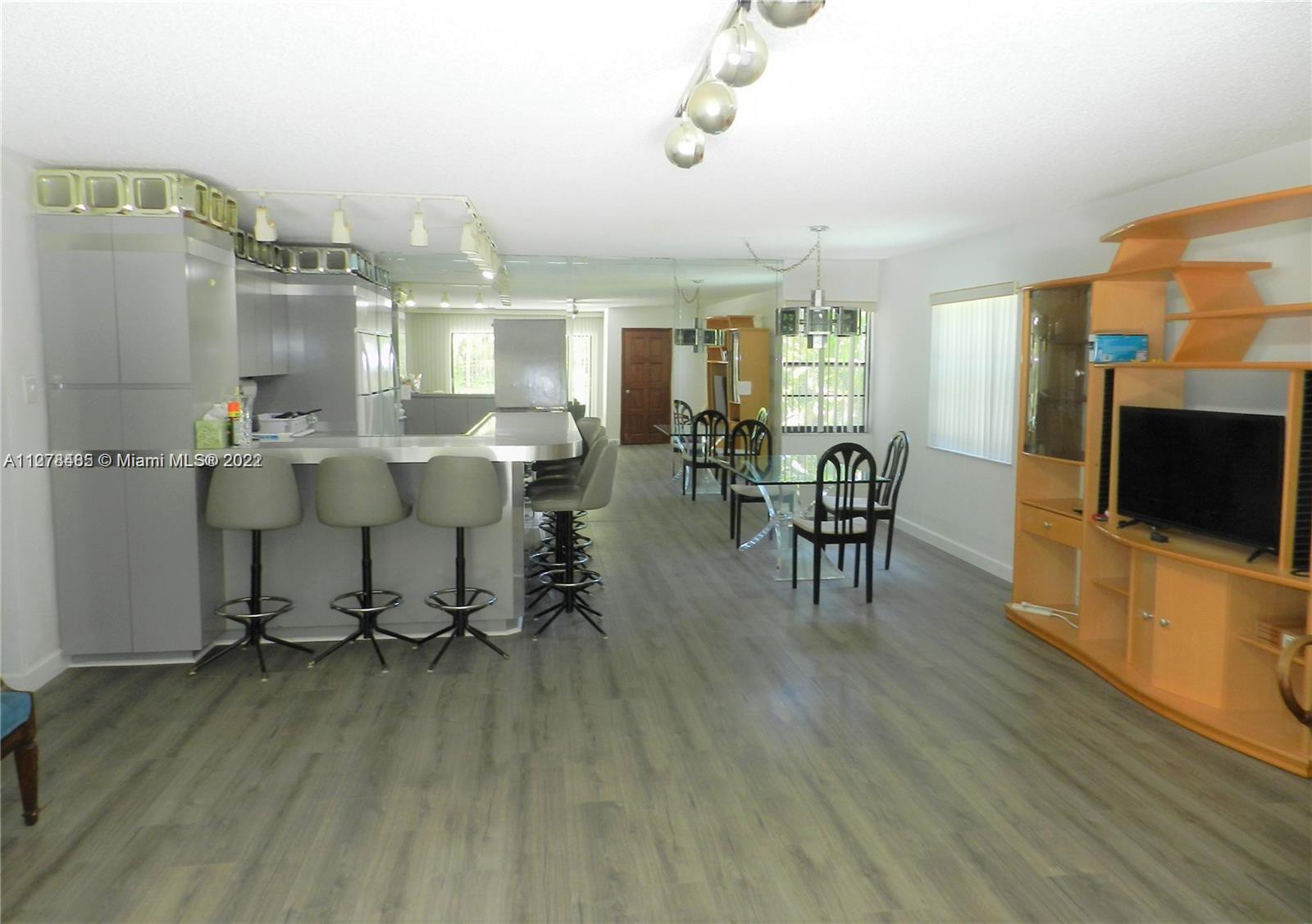 8927 Harding Avenue Surfside, FL 33154 - Photo 15 of 22 a view of a dining room with furniture window and wooden floor