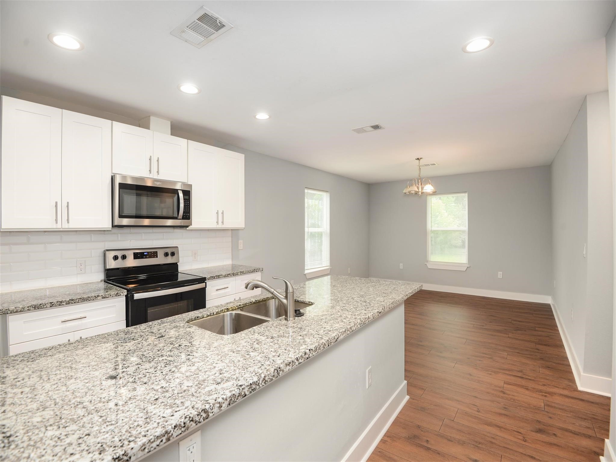7815 Jester Street Houston, TX 77051 - Photo 8 of 22 a kitchen with granite countertop a stove a sink and a microwave