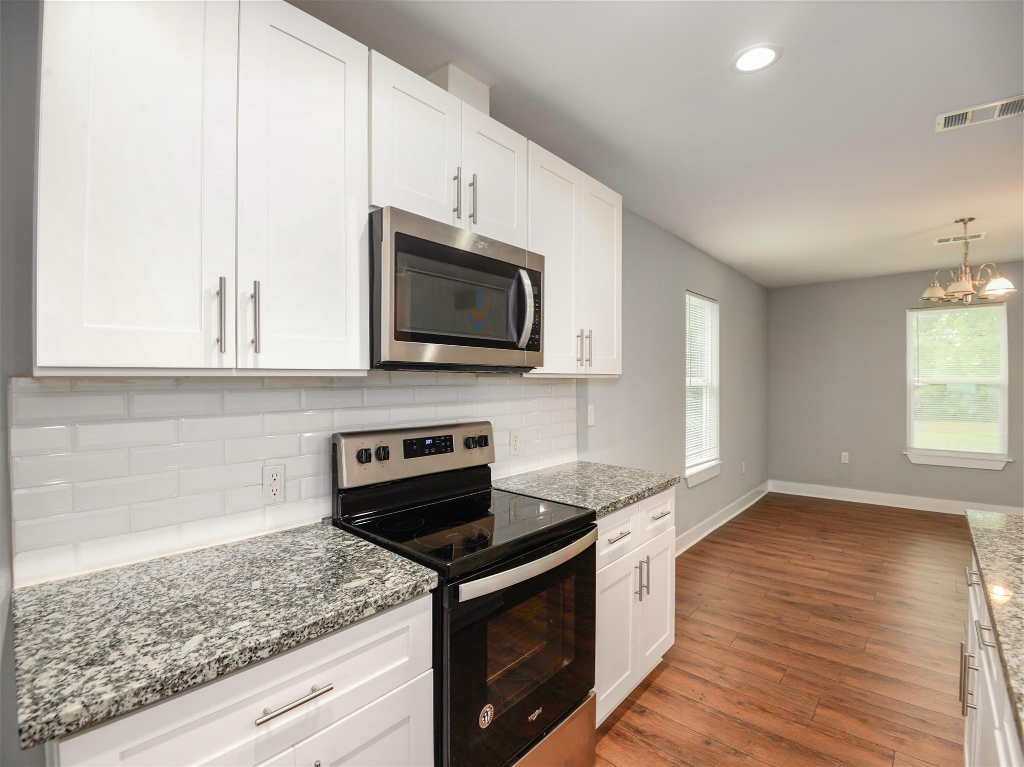 7815 Jester Street Houston, TX 77051 - Photo 9 of 22 a kitchen with stainless steel appliances granite countertop a sink a stove a microwave and wooden floors