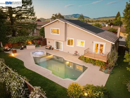 a view of a house with swimming pool and sitting area