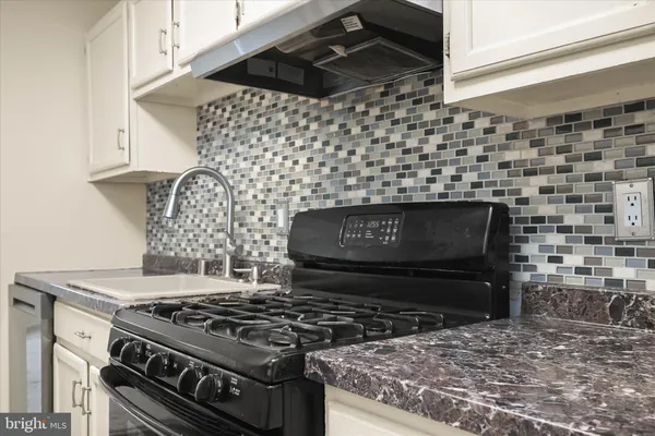 a stove top oven sitting inside of a kitchen