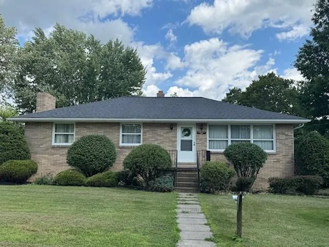 a front view of a house with yard and green space